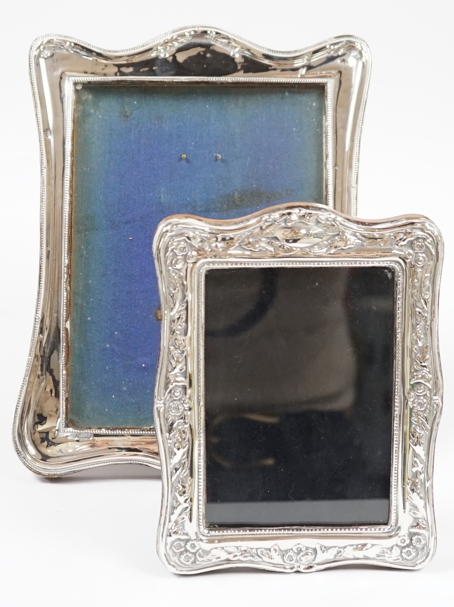A George V silver mounted photograph frame, Birmingham, 1917, 25cm, together with a modern silver mounted photograph frame. Condition - poor to fair